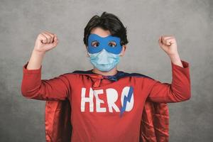 coronavirus, bambino con maschera medica vestito da supereroe foto