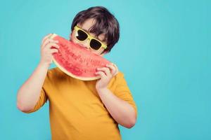 il bambino felice mangia l'anguria foto