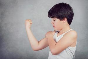 bambino che mostra i suoi muscoli foto