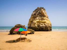 portogallo, algarve, due ombrelloni colorati in spiaggia, sabbiera per bambini in spiaggia foto