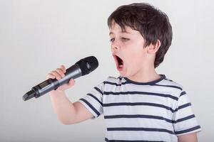 ragazzo che canta con un microfono foto