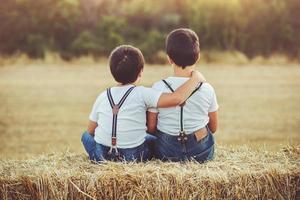 fratelli abbracciati seduti nel campo foto