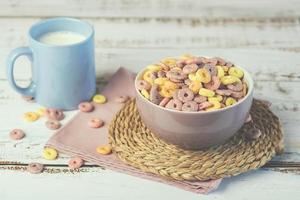 ciotola di cereali colorati con un bicchiere di latte foto