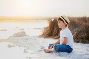 ragazzo triste e pensieroso seduto sulla spiaggia foto