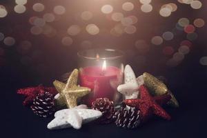 Buon Natale. candela accanto agli ornamenti di natale foto