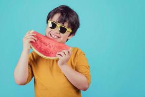 il bambino felice mangia l'anguria foto