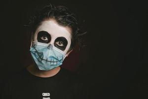 felice halloween.primo piano di un bambino che indossa una maschera medica in un costume da scheletro foto