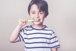 bambino che si lava i denti foto