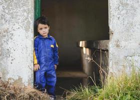 bambino triste e pensieroso accanto a una porta foto