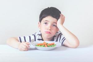 bambino triste con il cibo foto