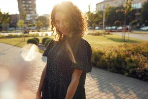 ritratti di un'affascinante ragazza dai capelli rossi con le lentiggini e un bel viso. la ragazza posa per la macchina fotografica nel centro della città. ha un ottimo umore e un dolce sorriso foto