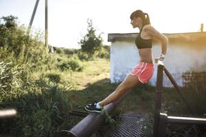 donna atletica che fa flessioni sulla natura foto