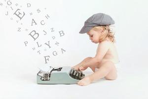 bambina con la vecchia macchina da scrivere foto