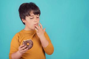 ragazzo che mangia la ciambella foto