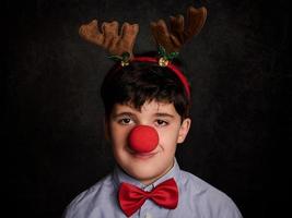 bambino felice con le renne da portare a natale foto