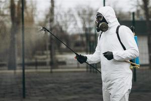 pulizia e disinfezione nel complesso cittadino in mezzo all'epidemia di coronavirus squadre professionali per gli sforzi di disinfezione prevenzione delle infezioni e controllo di tuta e maschera protettiva epidemica foto