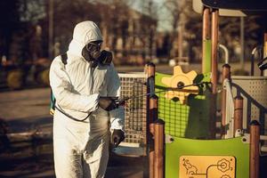 pulizia e disinfezione nel parco giochi nel complesso sity in mezzo alle squadre dell'epidemia di coronavirus per gli sforzi di disinfezione prevenzione delle infezioni e controllo della tuta e della maschera protettiva contro l'epidemia foto