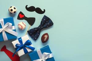 buona festa del papà. vista dall'alto di scatole regalo, papillon falso e palloni sportivi con spazio per la copia. concetto di celebrazione della festa del papà foto