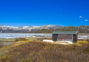 barche e vecchia casa lago ghiacciato vavatn paesaggio hemsedal norvegia. foto