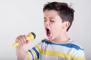 ragazzo che canta con un microfono foto