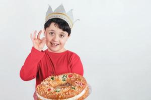 bambino sorridente con torta del re o roscon de reyes foto