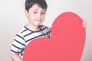 bambino felice con un cuore rosso foto