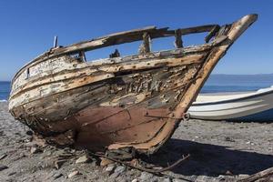 vecchia barca di legno abbandonata sulla spiaggia, un vecchio naufragio abbandonato stand sulla spiaggia o naufragato al largo di cabo de gata, almeria, andalusia, spagna foto