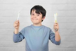 bambino felice che pulisce i denti con lo spazzolino da denti foto