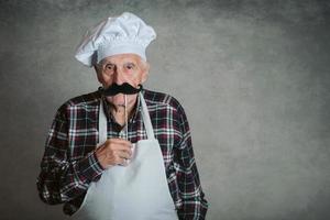 uomo anziano divertente con cappello da cuoco foto