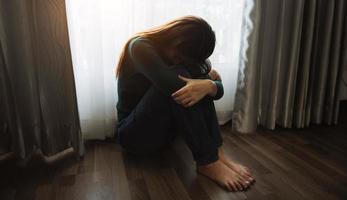 la donna si siede la depressione in piedi vicino alla finestra e lo spazio della copia dell'ansia. foto