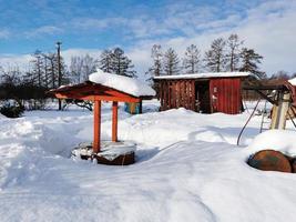 giornata invernale nel villaggio russo neve bene cielo blu foto