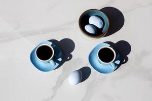 tazze di tè e uova blu con sfondo bianco foto