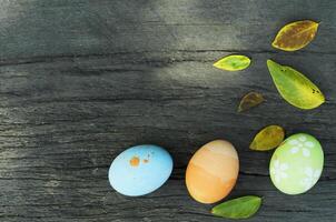 natura morta con uova di pasqua e foglie di atum su sfondi di legno foto