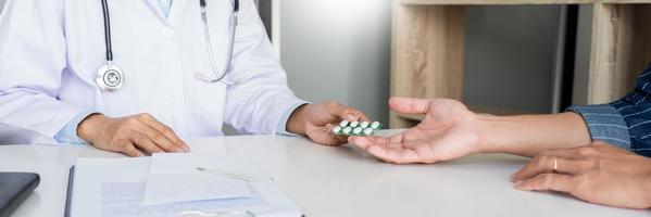concetto di assistenza sanitaria, il medico somministra una pillola di farmaci e spiega la direzione da utilizzare al paziente in ospedale