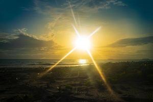 paesaggio al tramonto sulla spiaggia con luce solare intensa foto