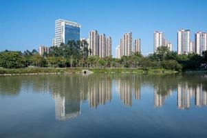 il fiume riflette i moderni edifici della città sotto il cielo blu foto