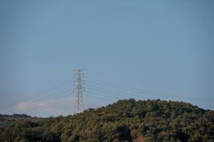 apparecchiature di trasmissione di potenza sulla montagna sotto il cielo blu foto