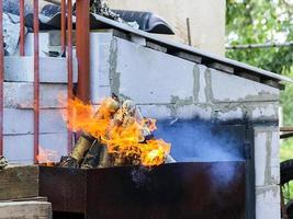 barbecue con braci ardenti e fiamme luminose foto