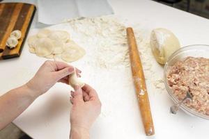 gnocchi fatti in casa in cucina senza decorazioni. fare gnocchi con carne di maiale macinata, manzo e pollo foto