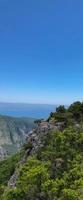 cielo blu nuvole bianche sulla collina, montagna con vista sugli alberi. foto