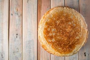 frittelle sottili appetitose su un fondo di legno. cibo russo per la vacanza maslenitsa. foto