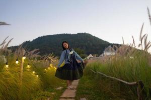 ritratto di donna in piedi nel campo di prato al tramonto foto