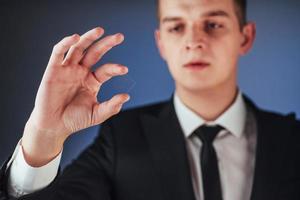 il giovane uomo d'affari in un vestito mostra la sua mano foto