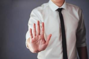 il giovane uomo d'affari in un vestito mostra la sua mano foto