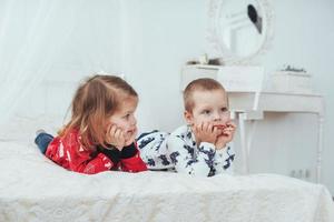 bambino in morbido pigiama caldo che gioca a letto foto