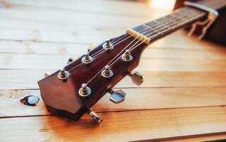 chitarra classica acustica al collo ravvicinata su sfondo di legno chiaro foto