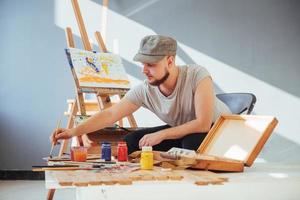 artista che dipinge un quadro in uno studio foto