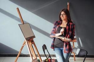 artista della giovane donna che dipinge un'immagine in studio foto