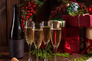 tavola delle vacanze di natale con bicchieri e una bottiglia di vino di champagne foto