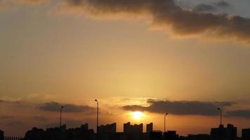 la splendida vista del tramonto con la silhouette e il cielo di nuvole colorate in città foto